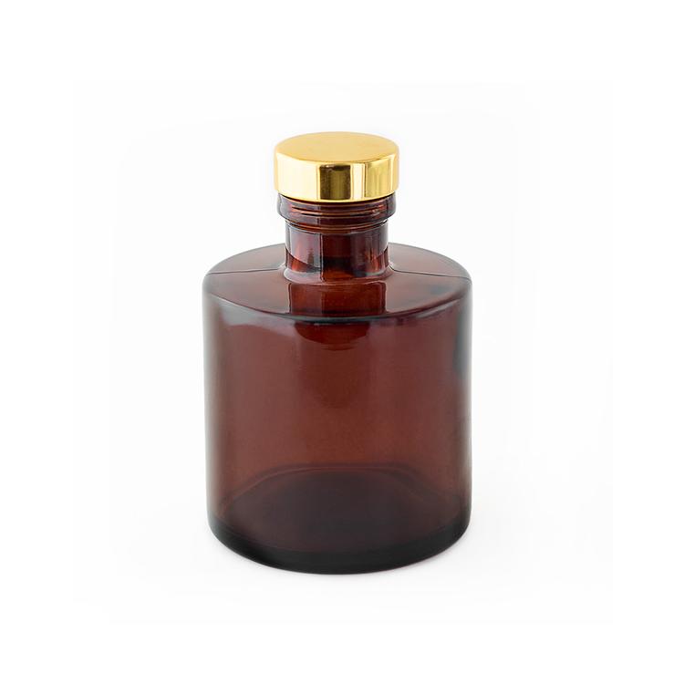 Amber Round Reed Diffuser Bottle with a Gold Stopper on a white background