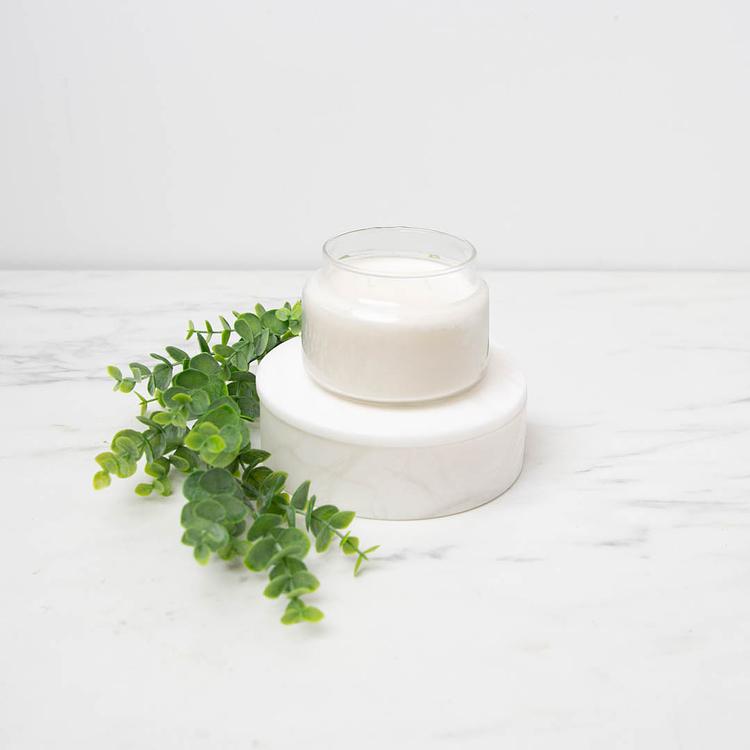8 oz. Apothecary Jar filled with a candle on a marble background on a raised podium