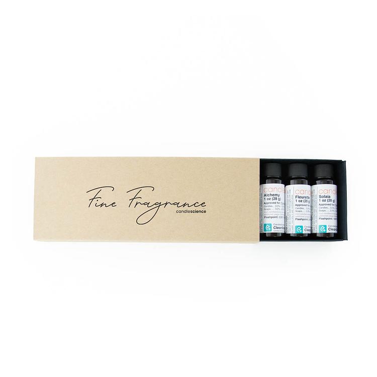 A Fine Fragrance Sampler Box partially opened to reveal 1 oz bottles on a white background