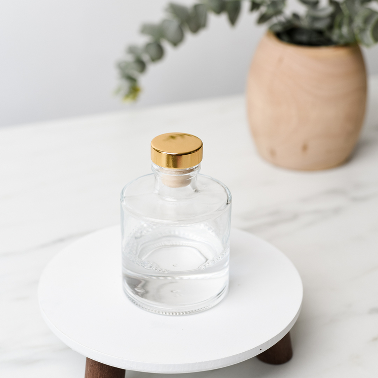 Round Reed Diffuser Bottle with Gold Stopper and Plant