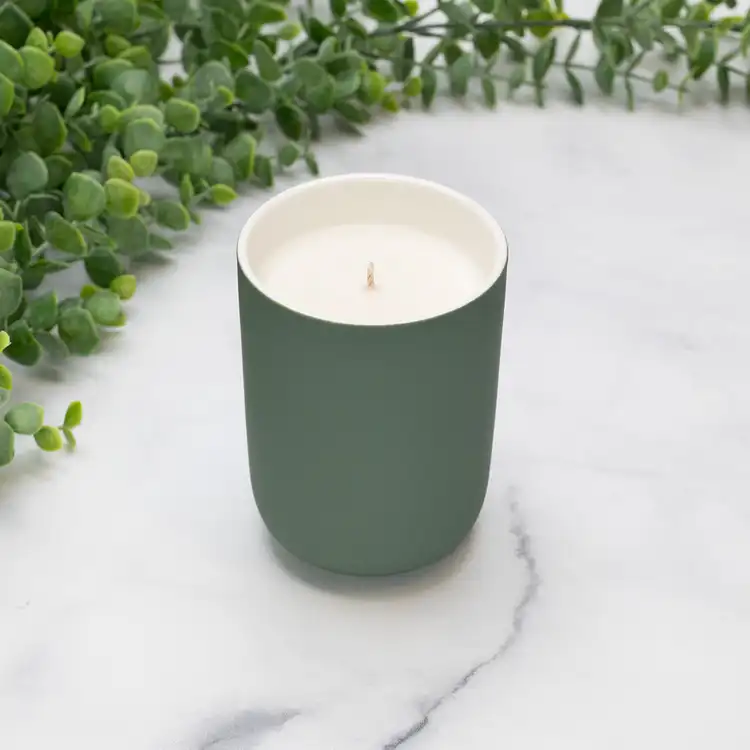Eucalyptus Dream Ceramic Tumbler Jar Candle in front of greenery