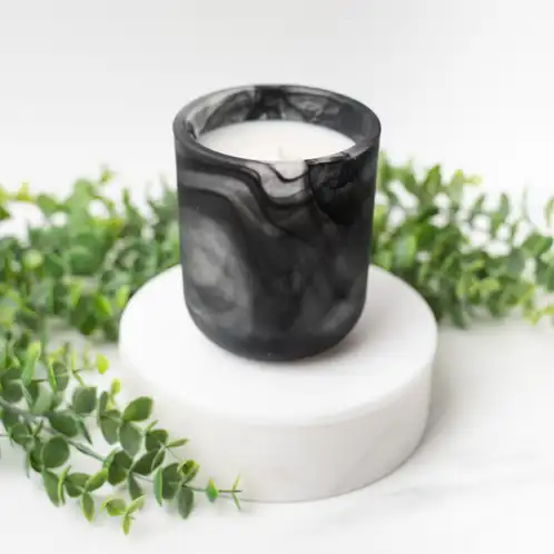 Frosted Black Swirl Sonoma Tumbler on a white marble podium surrounded by ivy with a white background.