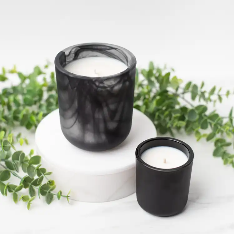 Frosted Black Swirl Sonoma Tumbler on a white marble podium paired with a Mini Matte Black Sonoma surrounded by ivy with a white background.