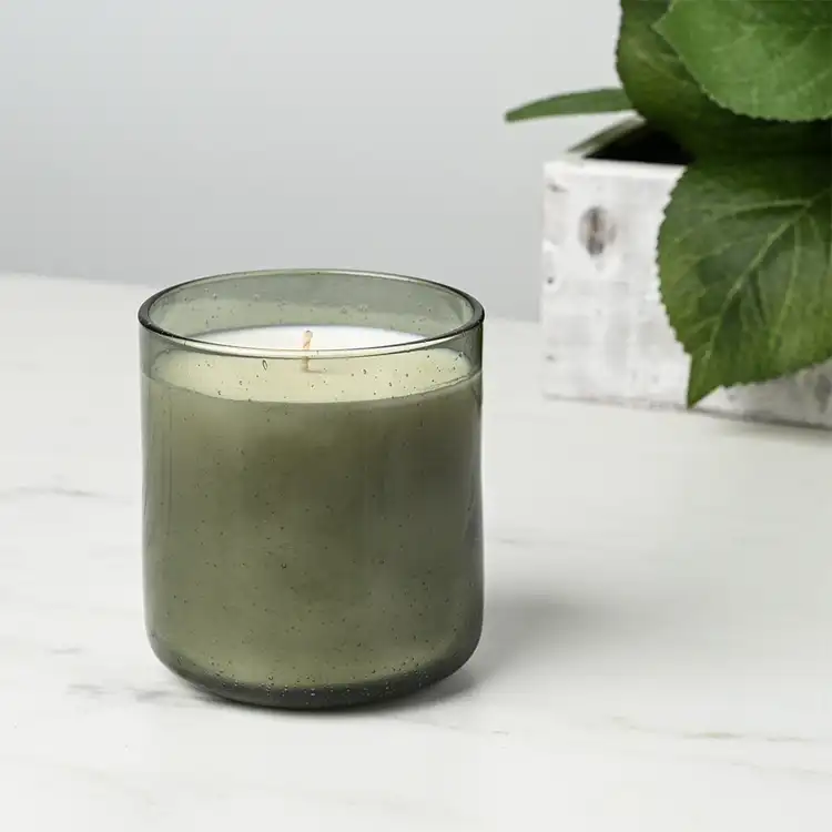 Smoked Olive Bubble Tumbler Jar candle in front of plant