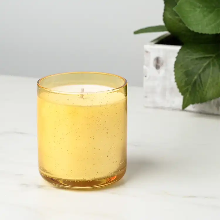 Yellow Bubble Tumbler Jar candle in front of plant