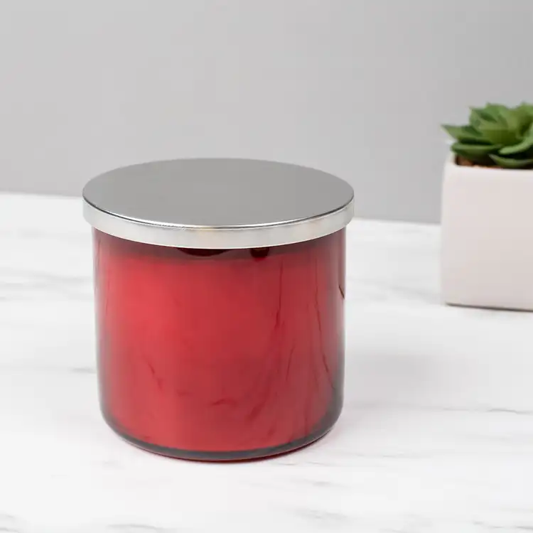 Red 3-Wick Tumbler Jar candle with Silver Metal Flat Lid (3-Wick) in front of plant