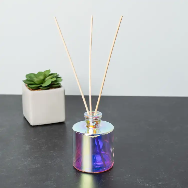 Prism Round Reed Diffuser Bottle with Natural Diffuser Reeds on black table