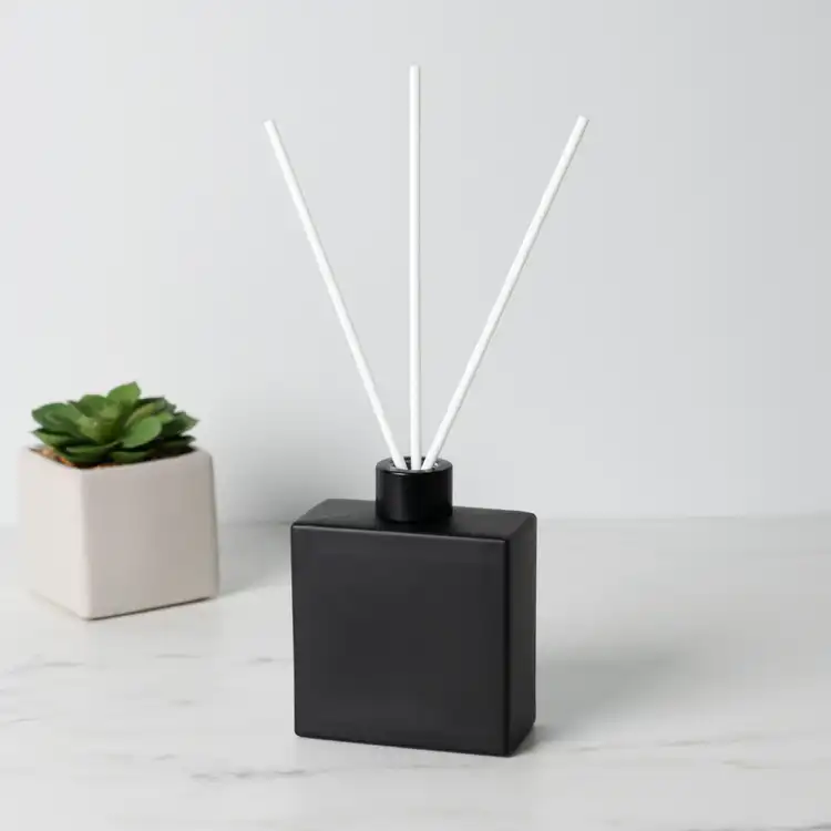 Matte Black Square Reed Diffuser Bottle with Matte Black Reed Diffuser Collar with White Fiber Diffuser Reeds on table