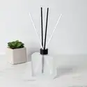 Frosted Square Reed Diffuser Bottle with Matte Black Reed Diffuser Collar and White and Black Fiber Diffuser Reeds on table