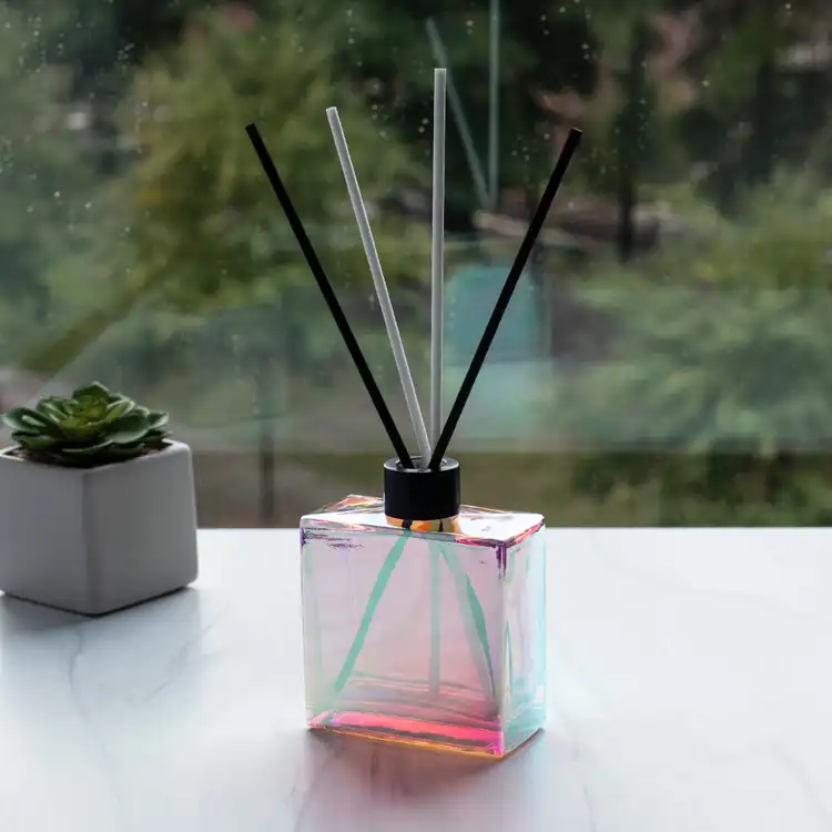 Prism Square Reed Diffuser Bottle with Matte Black Reed Diffuser Collar and Fiber Diffuser Reeds in front of window