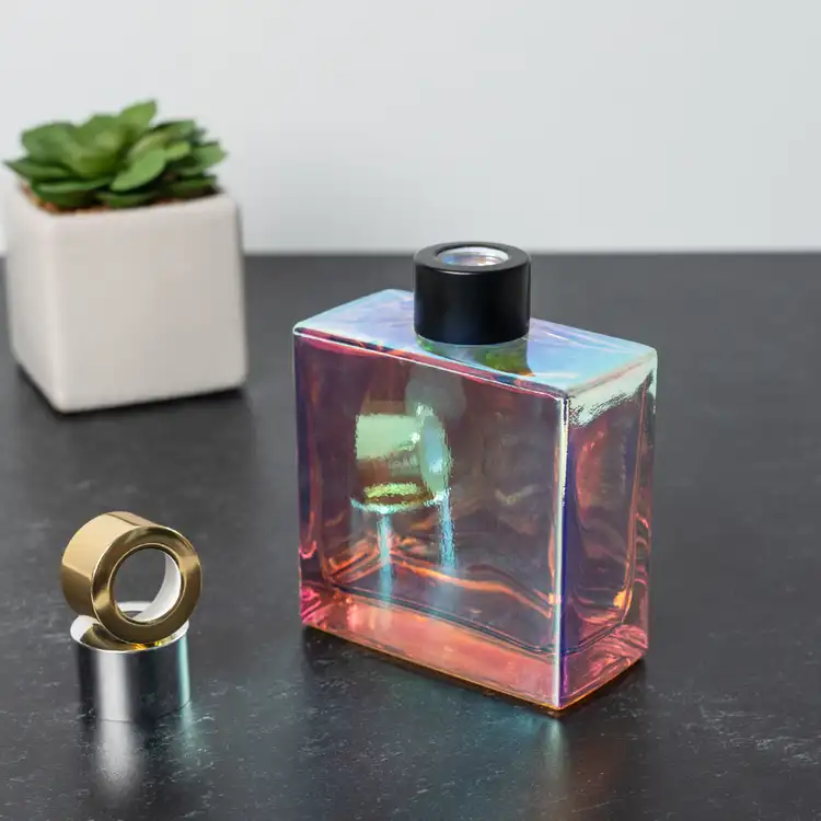 Prism Square Reed Diffuser Bottle with Matte Black Reed Diffuser Collar on black table next to Silver and Gold Diffuser Collars