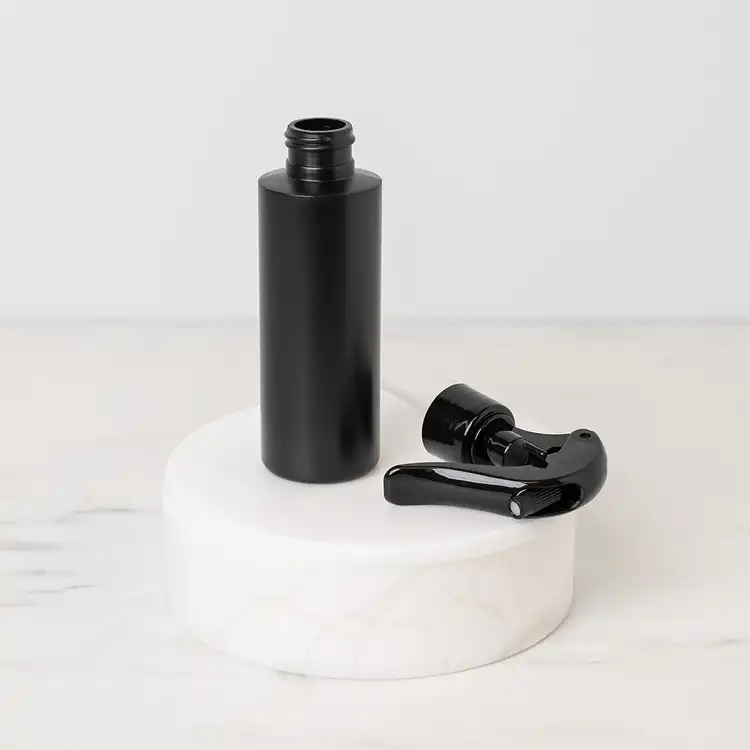 Matte Black 4 oz. HDPE Bottle beside Black Fine Mist Sprayer (24mm-410)