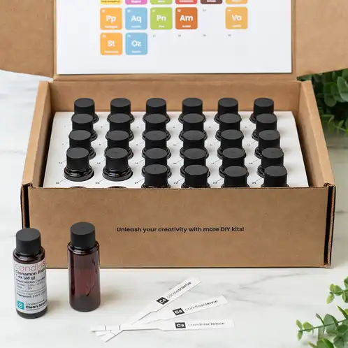 An open box of BlendingElements showing organized 1 oz bottles, one empty bottle for blending, and a 1 oz bottle with fragrance blotter strips.