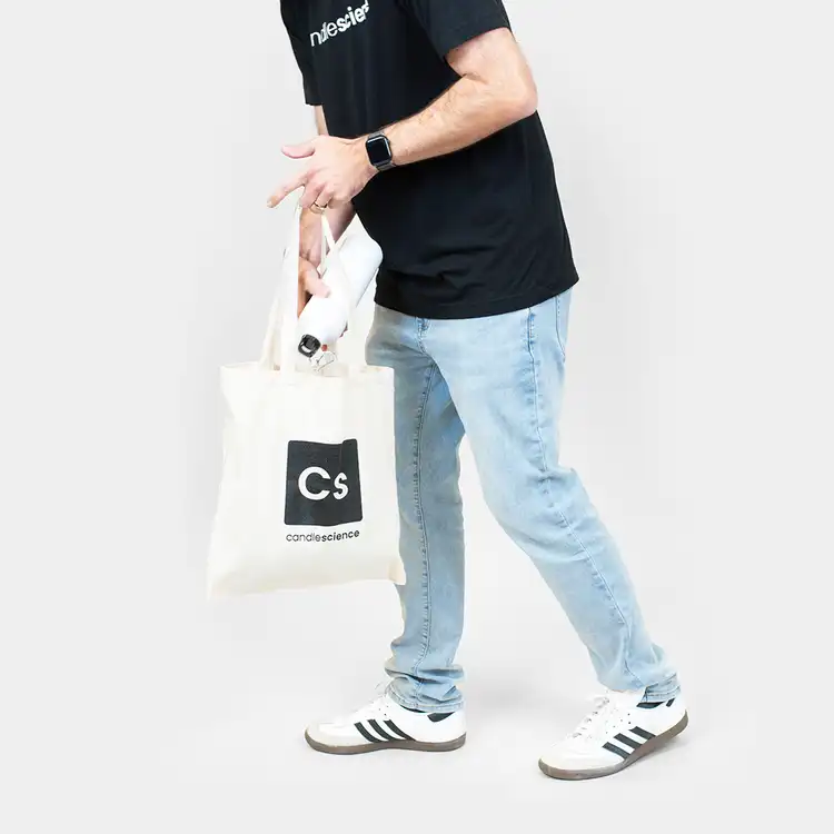 Person placing water bottle into Canvas CandleScience Tote Bag