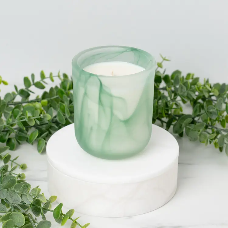 Frosted Green Swirl Sonoma Tumbler Jar candle in front of greenery