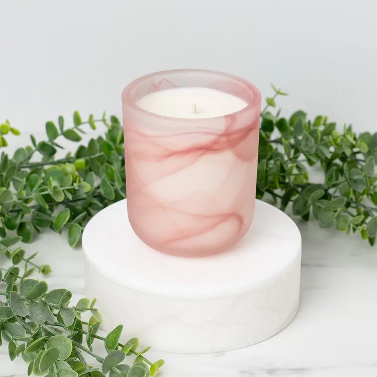 Frosted Pink Swirl Sonoma Tumbler Jar candle in front of greenery