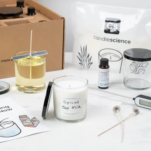 Starter+ Candle Making Kit in use with finished and labeled candles on a white marble countertop