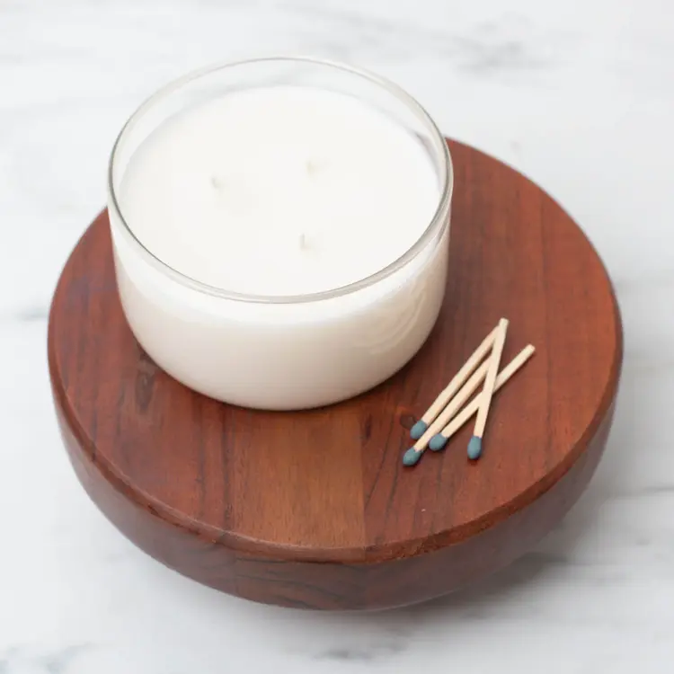 Clear Calista Tumbler Jar on a wooden riser with matches beside it.