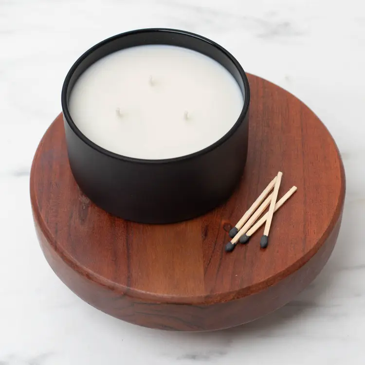 Matte Black Calista Tumbler Jar on a wooden riser with matches beside it.