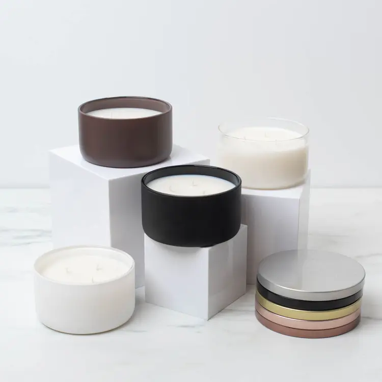 A Clear, Matte White, Matte Black, and Matte Mocha Calista Jar on risers with matching lids stacked to the side. 