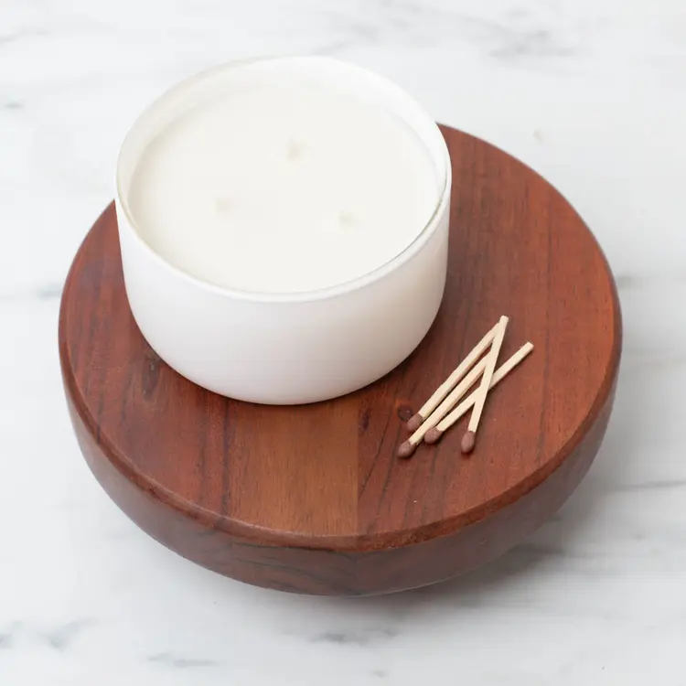 Matte White Calista Tumbler Jar on a wooden riser with matches beside it.