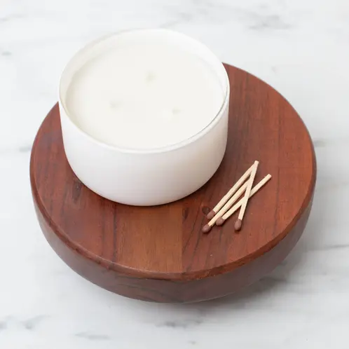 Matte White Calista Tumbler Jar on a wooden riser with matches beside it.
