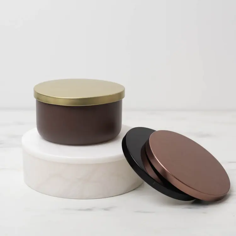 Matte Mocha Calista Tumbler Jar with Gold Metal Flat Lid on a white riser with metal flat lids stacked beside it.