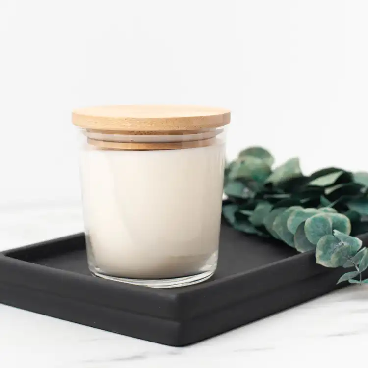 13.25 oz. Cidra Glass Tumbler Jar filled candle with a bamboo lid on a black tray