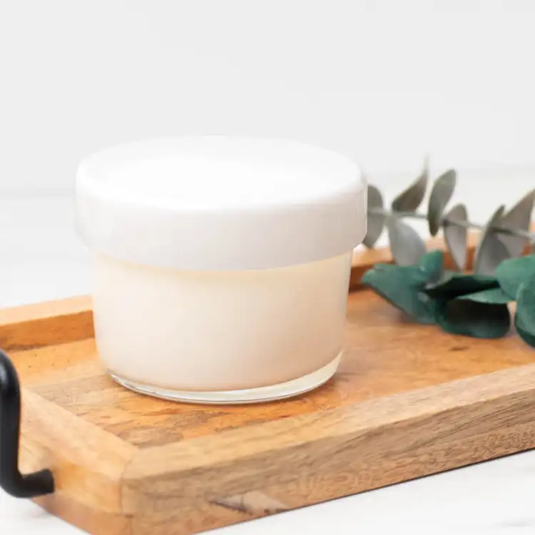 13.25 oz. Cidra Glass Tumbler Jar filled candle with a white glass tumbler lid lid on a wooden tray