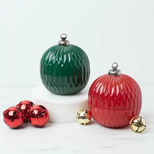 Red and Green Glass Ornament Jars on a marble countertop with red and gold bells.