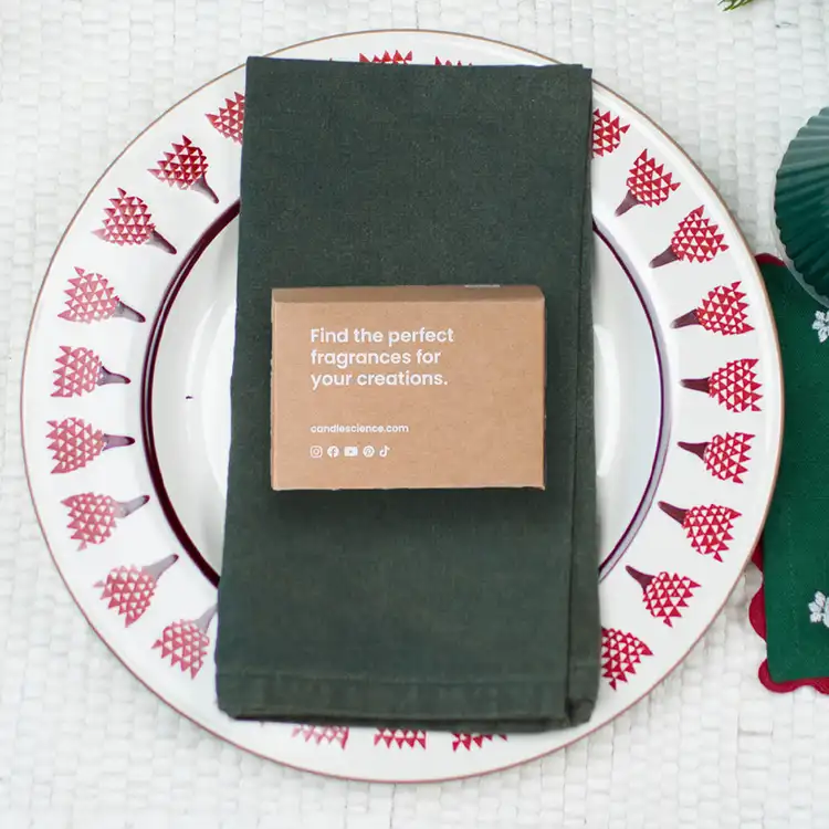 A fragrance flight box on a green linen napkin and Christmas plate. 