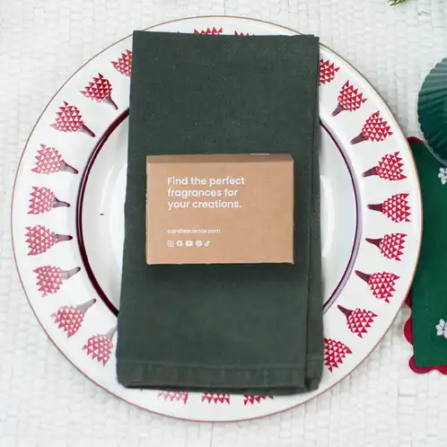 A fragrance flight box on a green linen napkin and Christmas plate. 