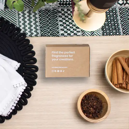 a kraft fragrance flight box on a wooden table beside artfully displayed spices and tablescapes. 