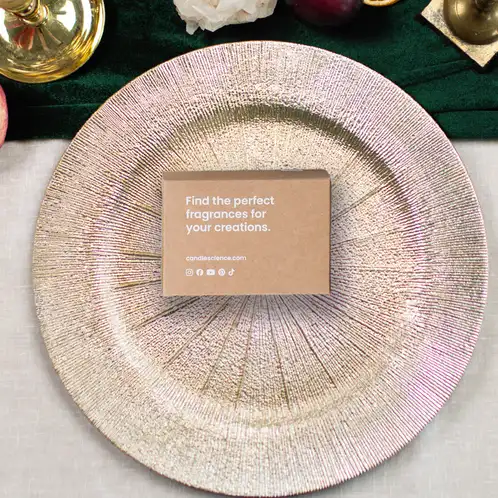 A kraft fragrance flight box on a gold platter on a beautifully set table.