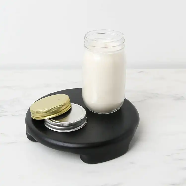 16 oz. Canning Jar filled with wax and wick black podium on a marble countertop