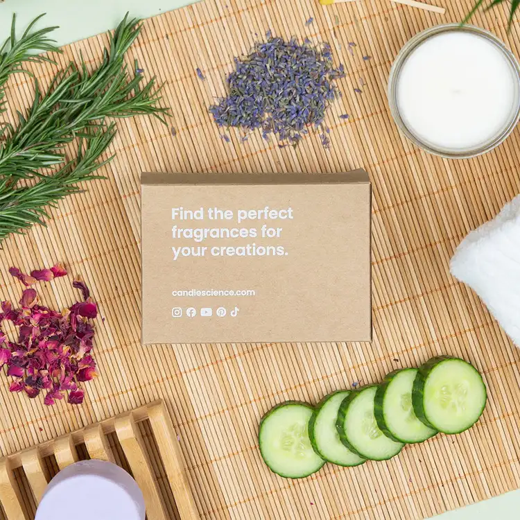 Relax and Unwind Fragrance Flight Box and 1 oz Fragrance Oils in a kraft box surrounded by fragrance note ingredients like cucumber slices, a bowl of cream, and lavender buds.