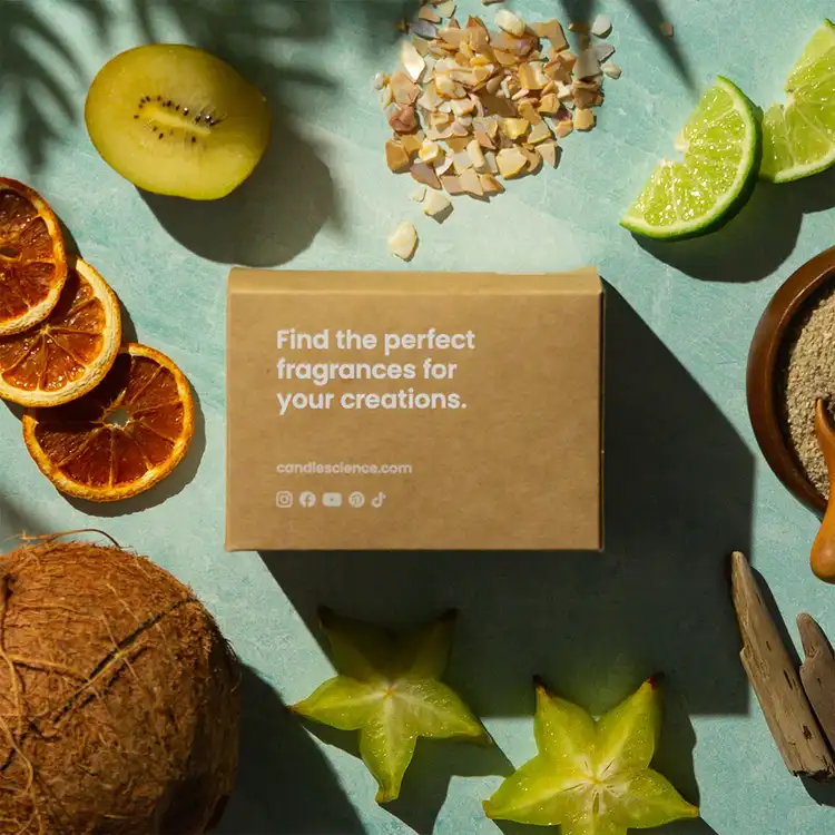 Summer Bliss Fragrance Flight Box and 1 oz Fragrance Oils on a teal table surrounded by fragrance notes like citrus slices, coconut, and starfruit