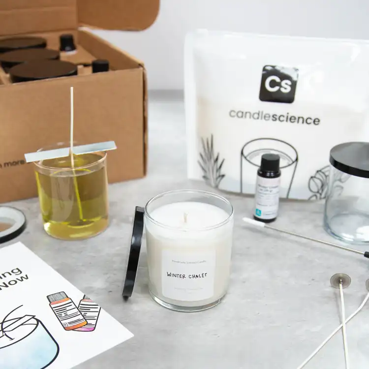 Starter+ Candle Making Kit in use with finished and labeled candles on a white marble countertop