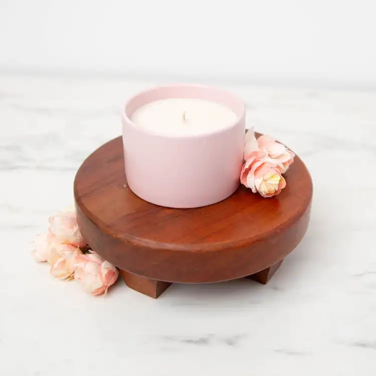 Mini Blush Modern Ceramic Tumbler with no lid on a wooden pedestal with rose buds scattered around the container 