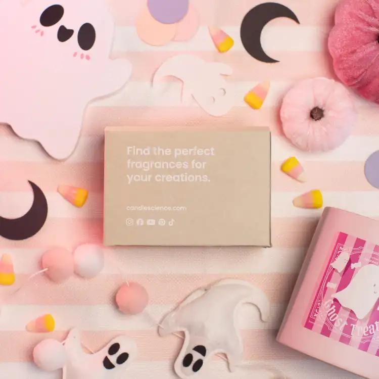 A kraft fragrance flight box that reads "find the perfect fragrances for your creations" surrounded by cute paper ghosts, pink and yellow candy corn, cozy fuzzy pink pumpkins