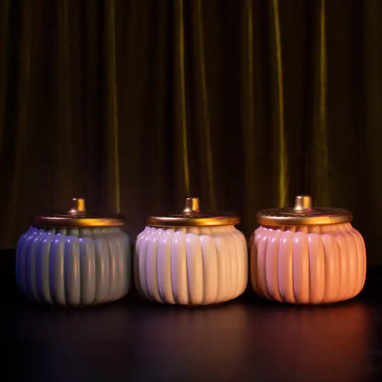 The trio of teal, ivory, and orange harvest ceramic pumpkin jars.