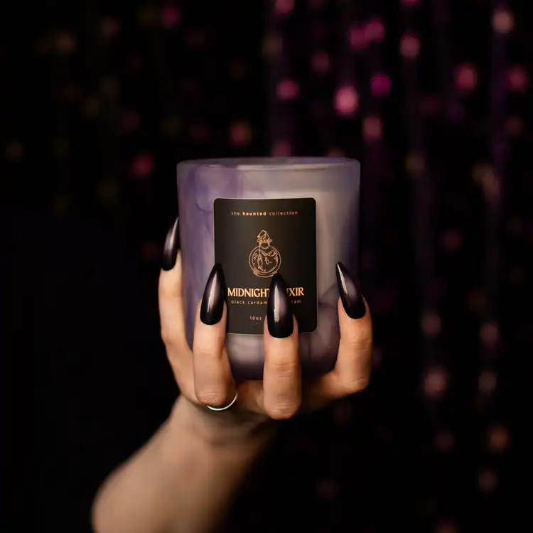 Frosted Purple Swirl Sonoma held in a hand with black fingernails and a black background