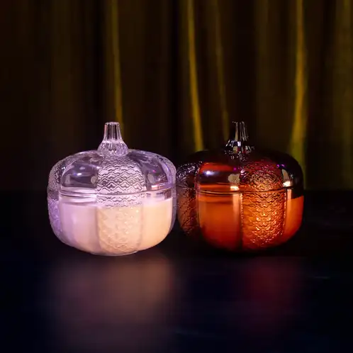 Heirloom Glass Pumpkin Jar beside Amber Heirloom Glass Pumpkin Jar on a dark and moody background