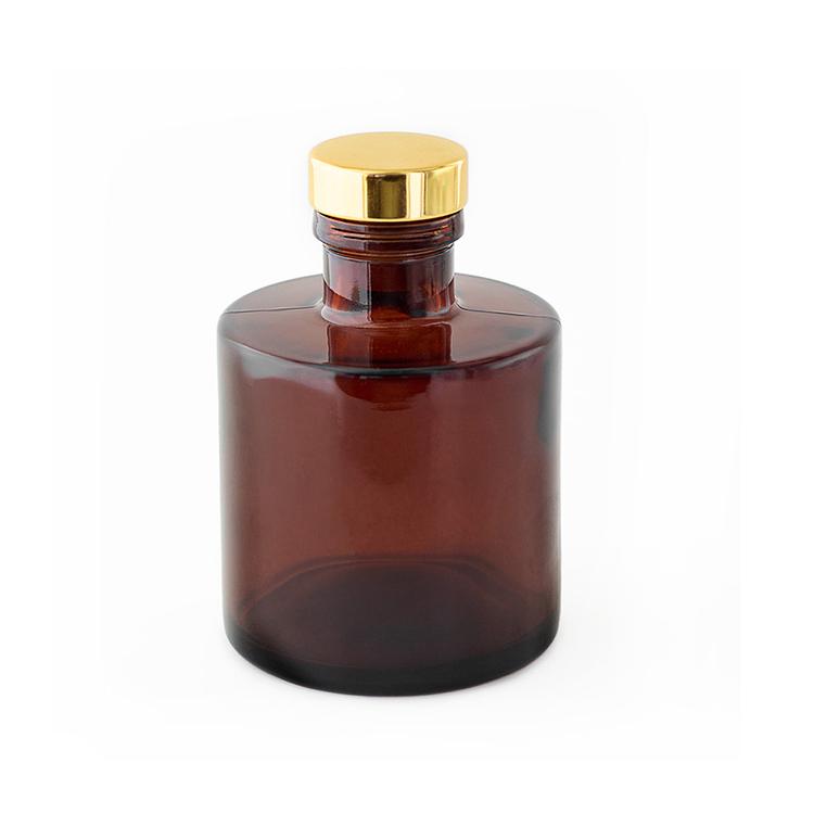 Amber Round Reed Diffuser Bottle with a Gold Stopper on a white background