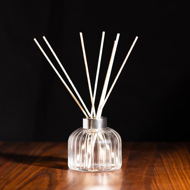Gatsby Reed Diffuser Bottle with a silver gatsby collar on wooden table with a shadowy background